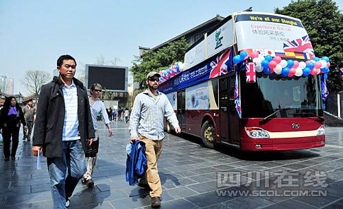在寬窄巷子，幾位外國游客從世博大巴旁經(jīng)過